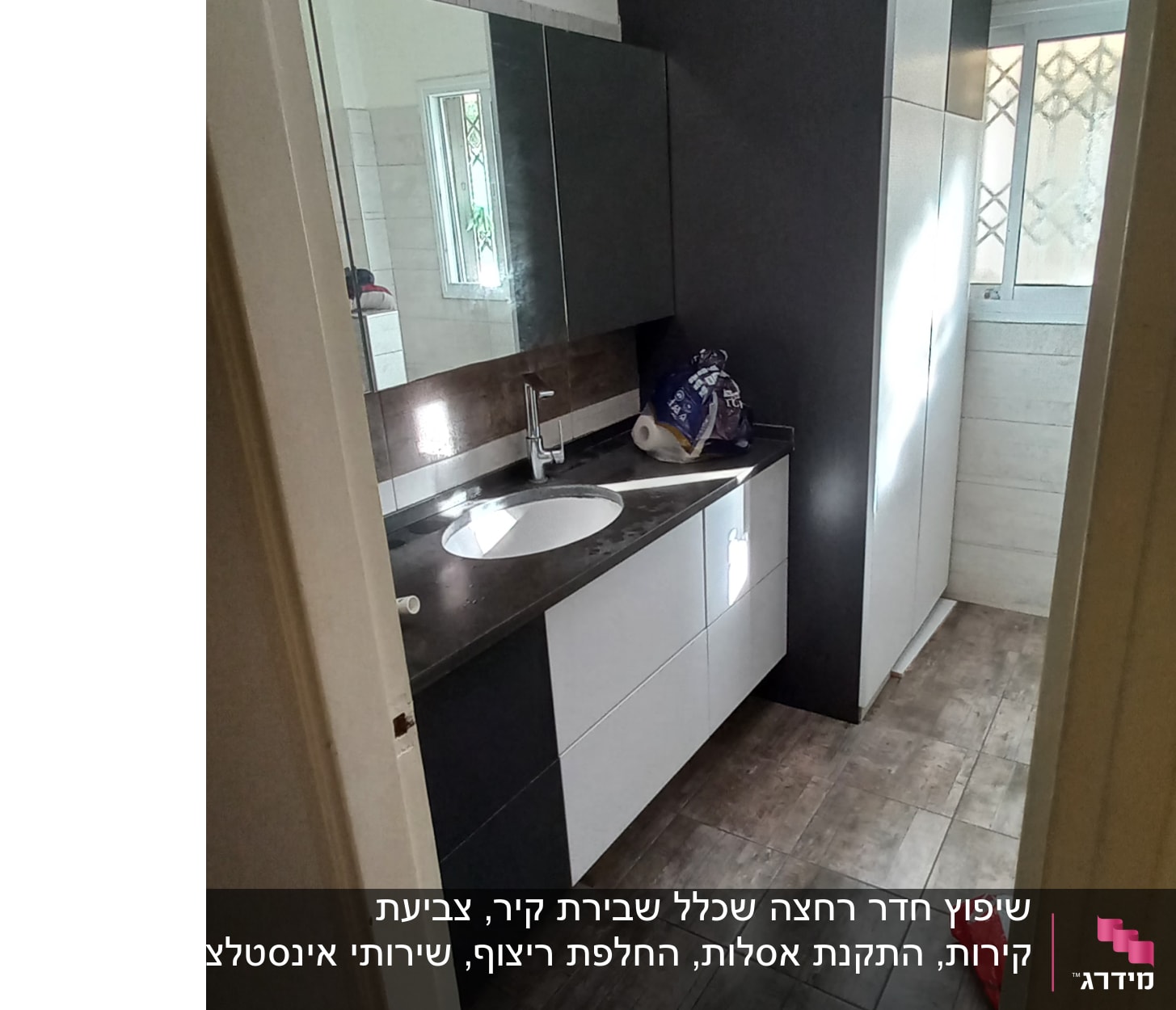 חדר אמבטיה עם ארונות חדשים, כיור ומשטח עבודה.